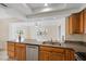 Kitchen featuring granite counters, stainless steel appliances, and wood cabinetry overlooking the dining and living areas at 4976 Cedarbrook Ln, Hernando Beach, FL 34607