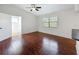 Bright bedroom with hardwood floors, ceiling fan, and natural light from a window at 507 E Curlew Pl, Tarpon Springs, FL 34689