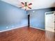 Bedroom with hardwood floors, blue walls, and bathroom access at 507 E Curlew Pl, Tarpon Springs, FL 34689