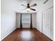 Bedroom featuring wood flooring, a closet, a ceiling fan, and a window for lots of light at 507 E Curlew Pl, Tarpon Springs, FL 34689