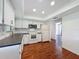 Bright kitchen featuring white cabinetry, modern appliances, and wood floors at 507 E Curlew Pl, Tarpon Springs, FL 34689