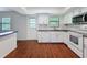Bright kitchen with white cabinets, stainless steel appliances, and dark countertops at 507 E Curlew Pl, Tarpon Springs, FL 34689