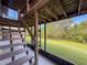 View of wood staircase on screened-in lanai overlooking lush backyard at 507 E Curlew Pl, Tarpon Springs, FL 34689