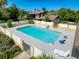 Community pool enclosed with a white fence, lounge chairs, and clear, clean water, perfect for enjoying a refreshing swim at 507 E Curlew Pl, Tarpon Springs, FL 34689