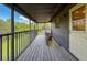 Long screened porch with wood deck and metal safety railing at 507 E Curlew Pl, Tarpon Springs, FL 34689