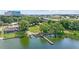 Aerial view of waterfront property with a long dock, well-maintained lawn, and mature trees at 5109 Vinson Dr, Tampa, FL 33610