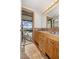 Bathroom with double sinks, wood cabinetry, and screened-in pool view at 5109 Vinson Dr, Tampa, FL 33610