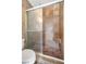 Tiled bathroom featuring a shower with a glass door and a built-in seat at 5109 Vinson Dr, Tampa, FL 33610