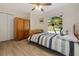 Bedroom with wooden wardrobe, window view of palm trees, and striped bedding at 5109 Vinson Dr, Tampa, FL 33610