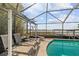 Relaxing screened-in pool area with lounge chairs and lake views at 5109 Vinson Dr, Tampa, FL 33610