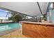 Screened pool area features a rustic wood bar, views of the lake, creating a relaxing outdoor space at 5109 Vinson Dr, Tampa, FL 33610
