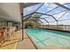 Screened-in pool area with bar seating, patio furniture, and beautiful lake views, perfect for entertaining at 5109 Vinson Dr, Tampa, FL 33610