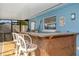 Outdoor bar seating area by the screened-in pool, perfect for enjoying the lake views at 5109 Vinson Dr, Tampa, FL 33610