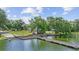 View of a dock on the water, with an American flag, playground, and shady trees visible in the background at 5109 Vinson Dr, Tampa, FL 33610