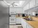 Efficient kitchen with white appliances, ample counter space, and a view of the dining area at 5157 Silent Loop # 208, New Port Richey, FL 34652