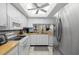 Bright and airy kitchen with white cabinets, stainless steel appliances, and ample counter space for cooking at 5157 Silent Loop # 208, New Port Richey, FL 34652