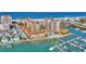 Gorgeous aerial view of luxury condos and a marina with boats docked in clear turquoise water at 521 Mandalay Ave # 307, Clearwater Beach, FL 33767