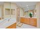 Bright bathroom featuring a double sink vanity with wood cabinets and a glass-enclosed shower at 521 Mandalay Ave # 307, Clearwater Beach, FL 33767