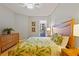 Bedroom features a bed with tropical bedding, a wood dresser, and sliding glass door to a patio at 521 Mandalay Ave # 307, Clearwater Beach, FL 33767