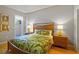 Bedroom features a bed with tropical bedding, a small sitting area, and sliding glass door to a patio at 521 Mandalay Ave # 307, Clearwater Beach, FL 33767