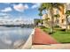 Beautiful waterfront building with lush landscaping, sidewalk, and scenic views at 521 Mandalay Ave # 307, Clearwater Beach, FL 33767