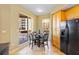 Cozy kitchen nook with black appliances, wood cabinets, and outdoor balcony access at 521 Mandalay Ave # 307, Clearwater Beach, FL 33767
