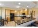Well-lit kitchen with light wood cabinets, black appliances, and seating at the breakfast bar at 521 Mandalay Ave # 307, Clearwater Beach, FL 33767