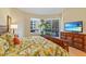 Bright main bedroom with natural light, balcony access, and an entertainment center at 521 Mandalay Ave # 307, Clearwater Beach, FL 33767