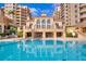 Community pool and patio with tan buildings in the background at 521 Mandalay Ave # 307, Clearwater Beach, FL 33767