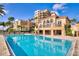 Resort-style pool surrounded by elegant buildings and lush landscaping at 521 Mandalay Ave # 307, Clearwater Beach, FL 33767