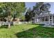 Spacious backyard with mature trees, fenced perimeter, shed, and screened in-ground pool at 5435 Birchwood Rd, Spring Hill, FL 34608