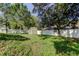Well-maintained backyard with a storage shed, white fence, and mature trees at 5435 Birchwood Rd, Spring Hill, FL 34608