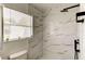 Bathroom with a window, marble tile in shower, and black shower head at 5435 Birchwood Rd, Spring Hill, FL 34608