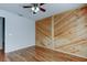 Bedroom features wood wall paneling, wood floors and a ceiling fan at 5435 Birchwood Rd, Spring Hill, FL 34608