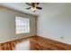 Bright bedroom with wood-look floors, a window, and ceiling fan at 5435 Birchwood Rd, Spring Hill, FL 34608