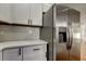 Close-up of the kitchen area with stainless steel refrigerator, and white cabinets and countertops at 5435 Birchwood Rd, Spring Hill, FL 34608