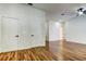 Bright living room with wood-look flooring, white walls, a ceiling fan, and multiple entry doors at 5435 Birchwood Rd, Spring Hill, FL 34608