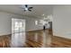 Open-concept living area with wood-look floors, ceiling fan, and a view of the modern kitchen and pool at 5435 Birchwood Rd, Spring Hill, FL 34608