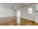 Spacious living room features wood-look floors, white walls, a ceiling fan, and sliding glass door at 5435 Birchwood Rd, Spring Hill, FL 34608