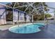 A gorgeous screened-in pool area with stylish outdoor curtains for privacy and shade at 5435 Birchwood Rd, Spring Hill, FL 34608