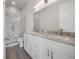 Modern bathroom with double vanity, granite countertop, marble tile shower, and sleek fixtures at 5530 N 9Th St # 6, Tampa, FL 33604