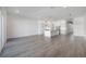 Spacious living room with light wood floors leading into an open kitchen with white cabinets and island at 5530 N 9Th St # 6, Tampa, FL 33604
