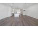 Open living room with light wood floors connects to a modern kitchen with island and white cabinets at 5530 N 9Th St # 6, Tampa, FL 33604