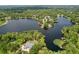 Stunning aerial view of a lakeside property with lush greenery, expansive lake access, and a serene residential setting at 5720 Half Moon Lake Rd, Tampa, FL 33625