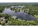 Stunning aerial view of lakefront homes surrounded by lush greenery and glistening water at 5720 Half Moon Lake Rd, Tampa, FL 33625