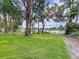 Expansive lawn stretching to the waterfront with majestic trees and serene views, perfect for outdoor enjoyment at 5720 Half Moon Lake Rd, Tampa, FL 33625