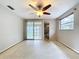 Bedroom with ceiling fan, ensuite bathroom, and sliding glass door access to an enclosed patio at 5720 Half Moon Lake Rd, Tampa, FL 33625