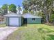 Charming home exterior featuring a garage, well-maintained lawn, and mature trees providing curb appeal at 5720 Half Moon Lake Rd, Tampa, FL 33625