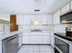 The kitchen features white cabinets, stainless appliances, white tile and an eat-in area overlooking the backyard at 5720 Half Moon Lake Rd, Tampa, FL 33625
