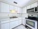 The kitchen features white cabinets, stainless appliances, tile backsplash and an eat-in area overlooking the backyard at 5720 Half Moon Lake Rd, Tampa, FL 33625